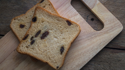 Raisin bread and cookie jar on wooden block