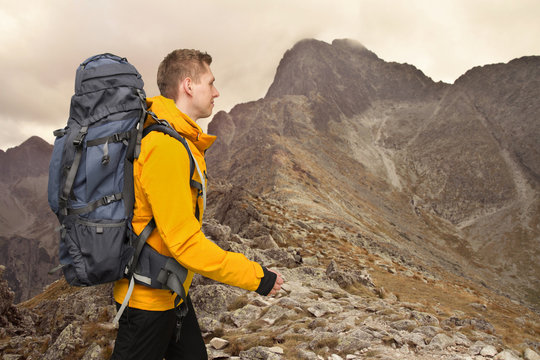 hiker man with big backpack in mountains