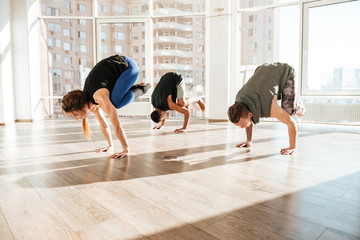Group of people balancing on hands and practicing yoga