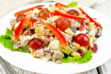 Salad of meat and cheese with grapes on green lettuce