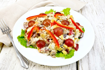 Salad of meat and cheese with grapes on light board