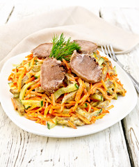 Salad of tongue and carrots with napkin on light board