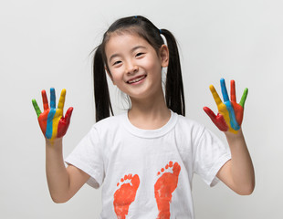 Little Asian girl with hands painted in colorful paints