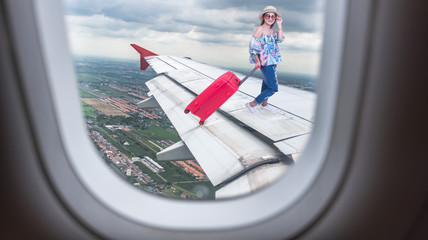 traveler woman walking on an airplane wing carrying a suitcase Travel concept