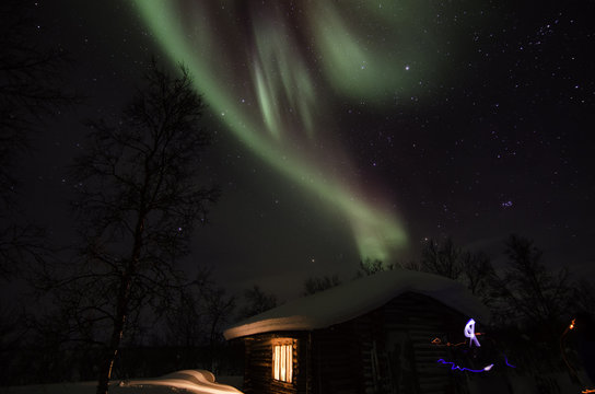 Northern lights over the cottage in lapland landscape in Finland
