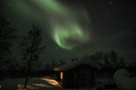 Northern lights over the cottage in lapland lanscape
