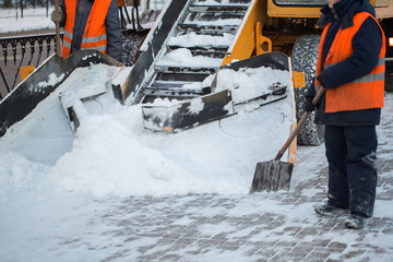 Tractor cleaning the road from the snow. Excavator cleans the streets of large amounts of snow in...