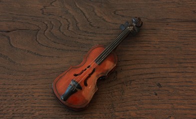Fototapeta na wymiar Violin miniature on wooden background