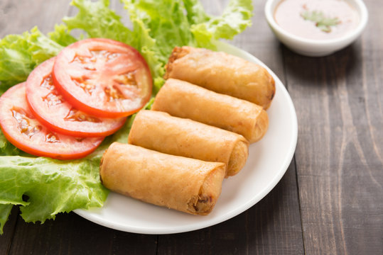 Fried Chinese traditional spring rolls on wooden background.