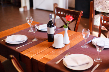 Dinner in the restaurant. Cutlery, wine and a rose on the table