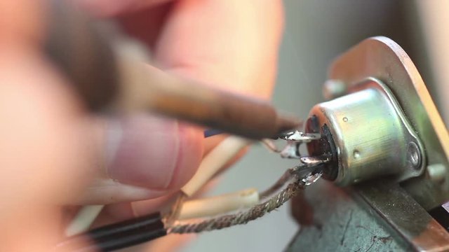 man soldering colored wires  to the Electronic Components