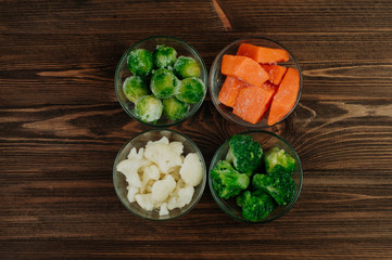 Frozen vegetables on rustic wood background