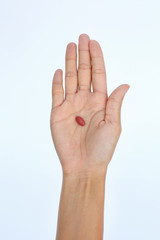 Close-up hand of a woman with some pills on white background