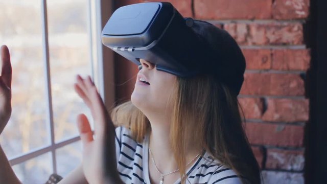 Close-up shot of woman getting experience in using VR-headset at home