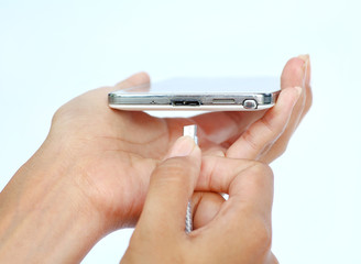 Close-up hands of woman connects plug of charger mobile phone or smartphone charging on white background