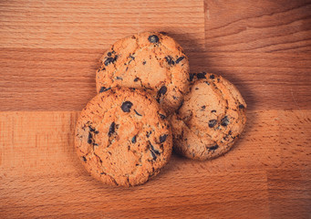 Home made chocolate cookies on wooden background. Crispy chip biscuits with chocolate and hazelnuts. Delicious fresh chocolate chip cookies.