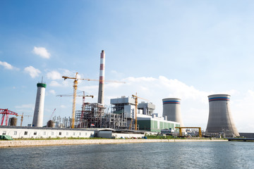 Obraz premium modern power plant near river in blue sky