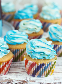 cupcakes with cream cap blue on white wooden background