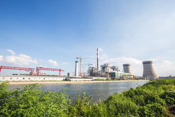 modern power plant near river in blue sky
