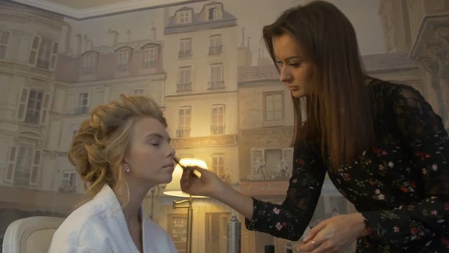 Makeup artist paints a Woman for the wedding