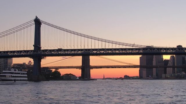 Spectacular view of Manhattan bridge and Brooklyn bridge against golden sunset