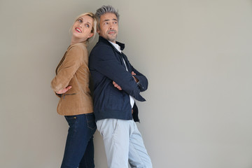 Middle-aged couple standing on grey background, isolated