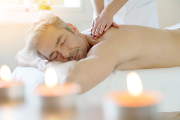 Obraz na płótnie Canvas Man relaxing on massage table receiving massage