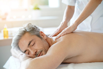 Obraz na płótnie Canvas Man relaxing on massage table receiving massage