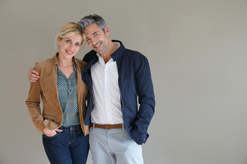 Middle-aged couple standing on grey background, isolated