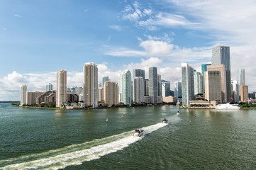 Fototapeta na wymiar Aerial view of Miami skyscrapers with blue cloudy sky, boat sail