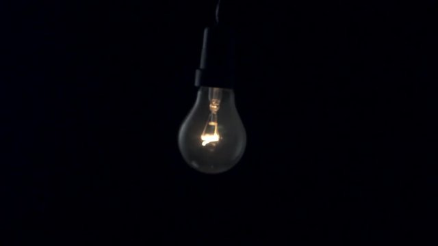 Light bulb swinging to camera. Slow motion.