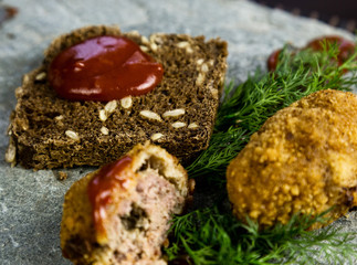Homemade meat cutlets with parsley, ketchup and bread on white plate