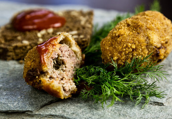 Homemade meat cutlets with parsley, ketchup and bread on white plate