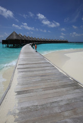Traditional Maldives bungalows on wooden pier in tropical paradise