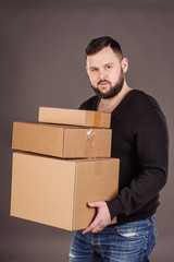 man holding pile of cardboard boxes in front