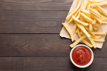 French fries with ketchup on wooden background