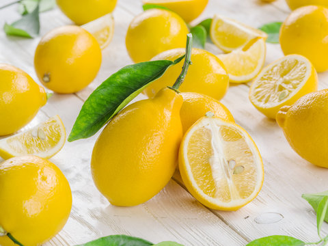 Ripe lemon fruits on the white wooden table.