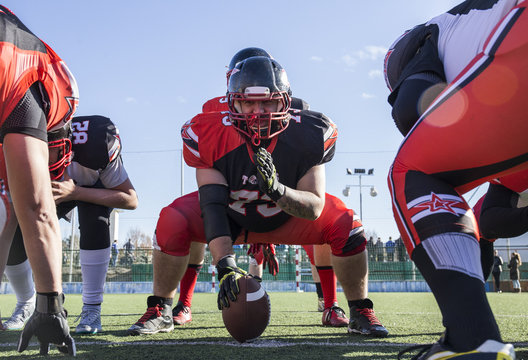 American football players on the line of scrimmage during a match