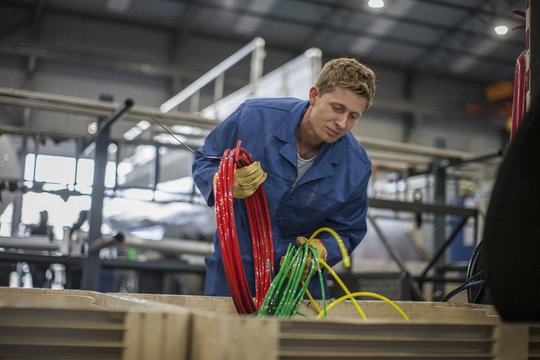 Factory worker in truck manufacture sorting cables in to box