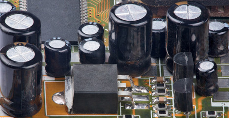 part of electrical board with many capacitors