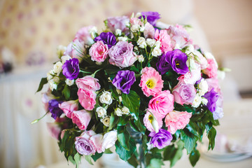 A bouquet of flowers in a glass vase on a wedding table