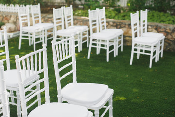 Fototapeta na wymiar Beautiful white wedding chairs at the ceremony in the Park.
