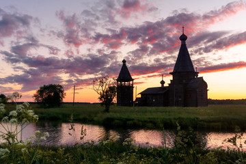 Fototapeta premium Ancient wooden church in Saunino village near Kargopol at sunrise, Russia