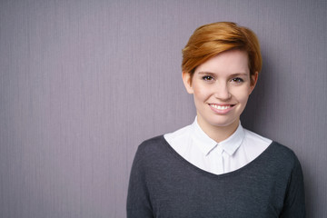 moderne junge frau steht vor einer grauen wand