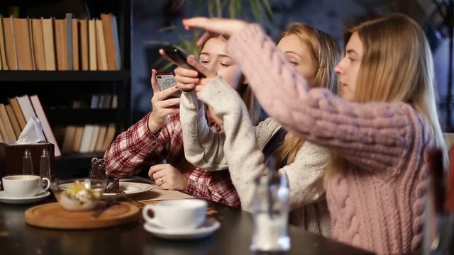 Girls taking photos of dessert with mobile phones
