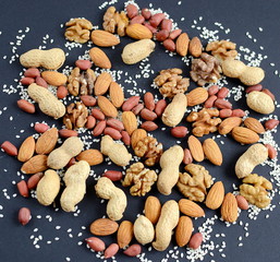 Assorted mixed nuts, peanuts, almonds, walnuts and sesame seeds.  Black background
