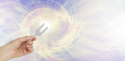 If you could see the sound waves make by an Angel Tuning Fork - female hand holding a short aluminum tuning fork on a graphic depiction of angelic sound waves background - obrazy, fototapety, plakaty