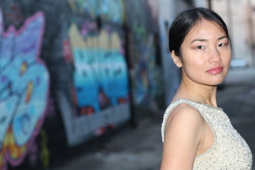 Elegant Asian woman in dark urban alley way isolated with copy space 