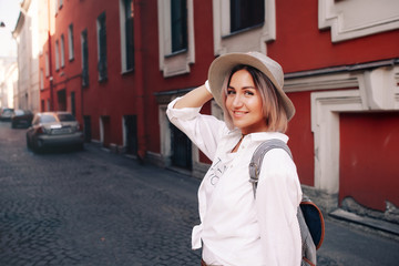 Fototapeta premium Travel guide. Young female traveler with backpack and with map on the street.