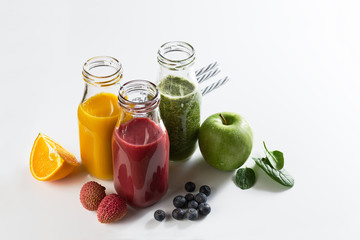 Tasty colorful fresh homemade smoothies in glass jars on bright background. Healthy life, detox concept.